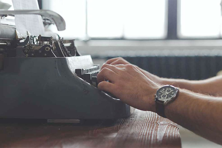 person typing on typewriter